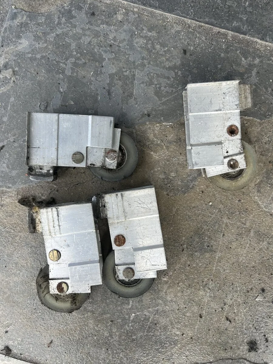 Worn sliding door rollers removed onto floor tile