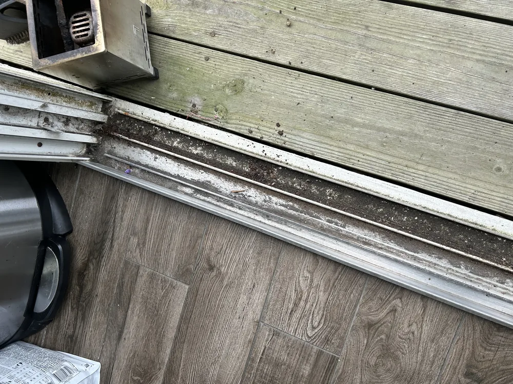 Weathered sliding door track along a deck